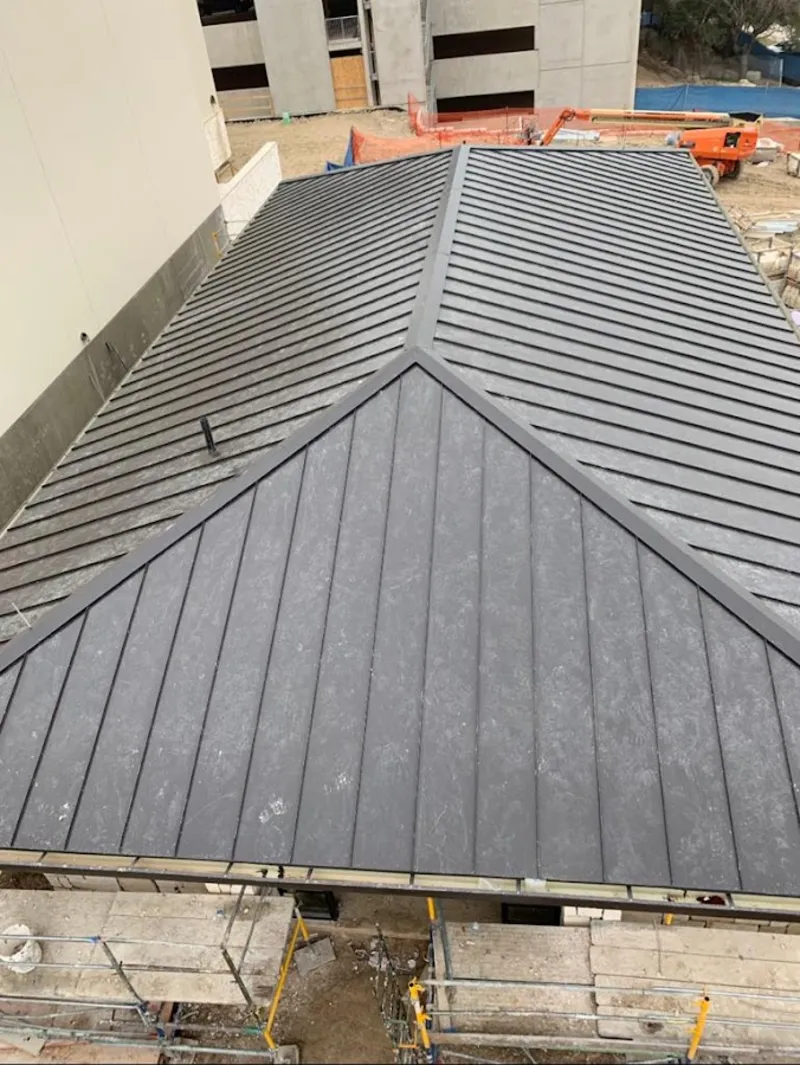 Commercial metal roof construction with crane equipment in Missouri City